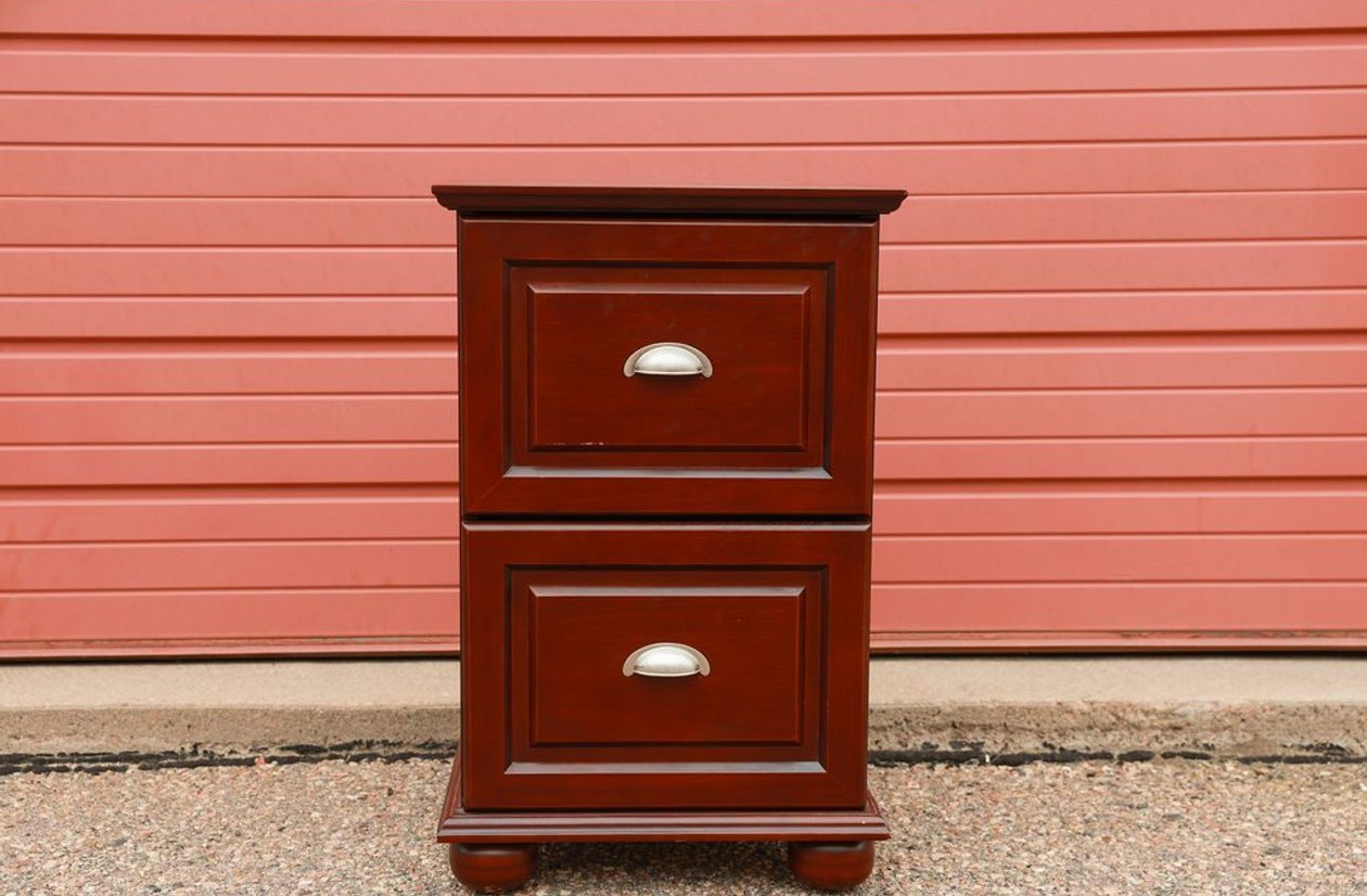 Cherry finish 2-drawer file cabinet with raised panel detail, brushed nickel cup pulls, and bun feet