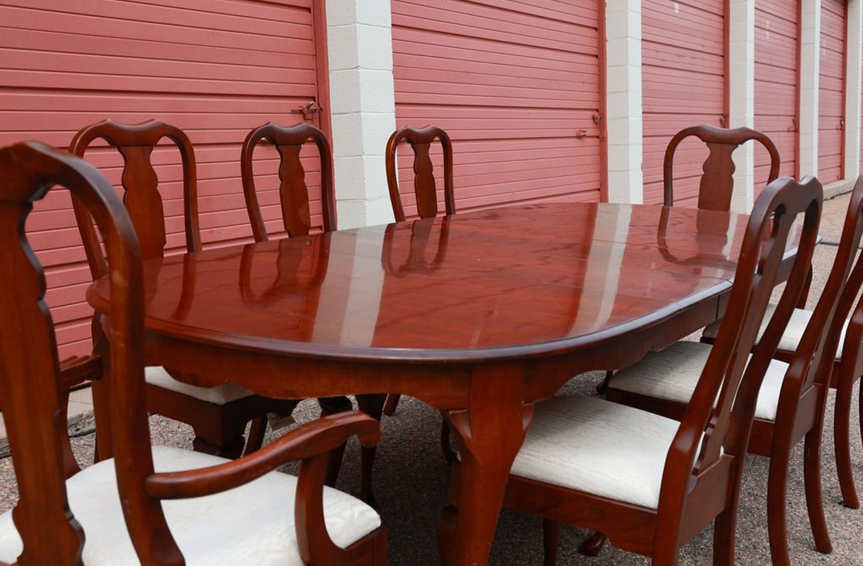 Cherry wood formal dining table with 8 Queen Anne chairs and upholstered cream seats